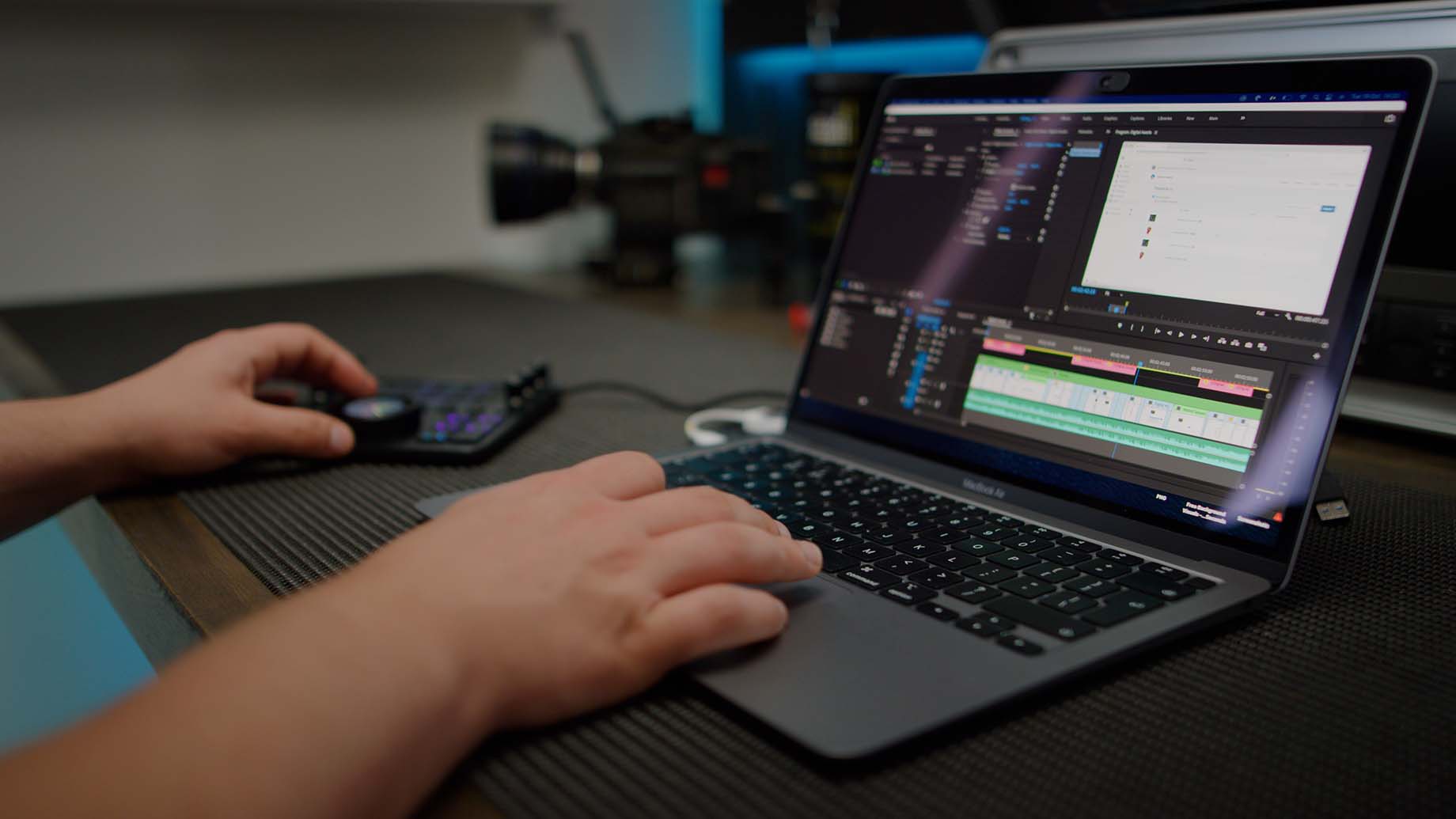 premiere pro on macbook air on desk with hand